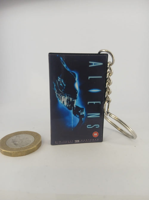Aliens VHS keyring — back cover angled view standing