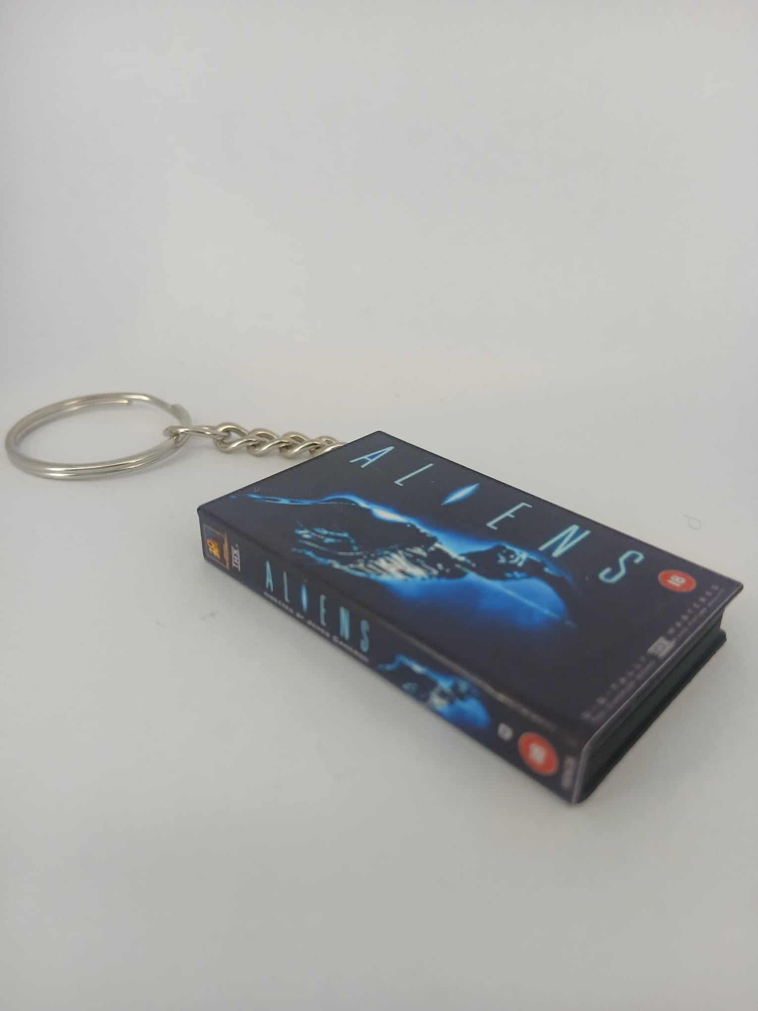 Aliens VHS keyring — back and spine angled view standing