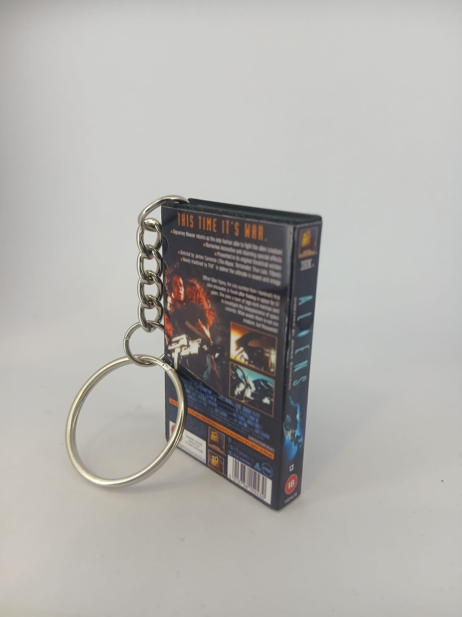 Aliens VHS keyring — front and spine angled view standing