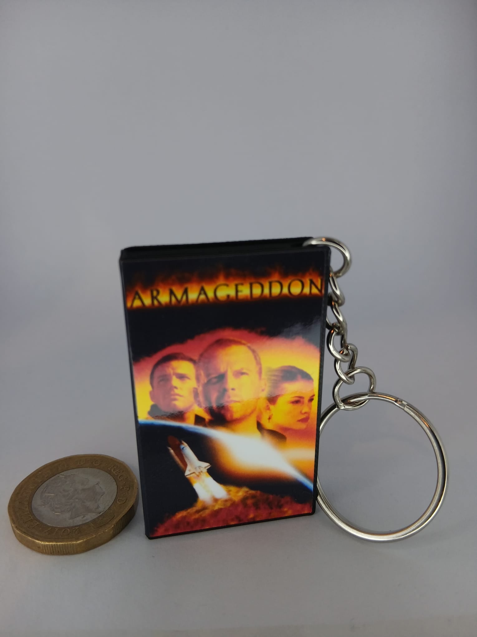 Armageddon VHS keyring — front cover with £1 coin for scale