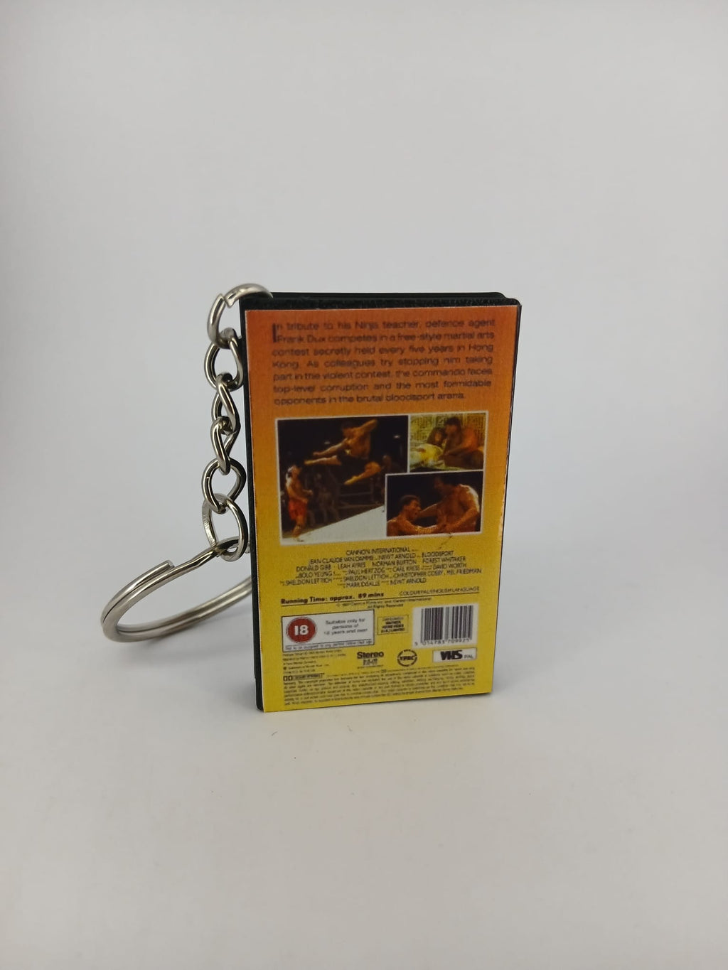 Bloodsport VHS keyring — spine view standing
