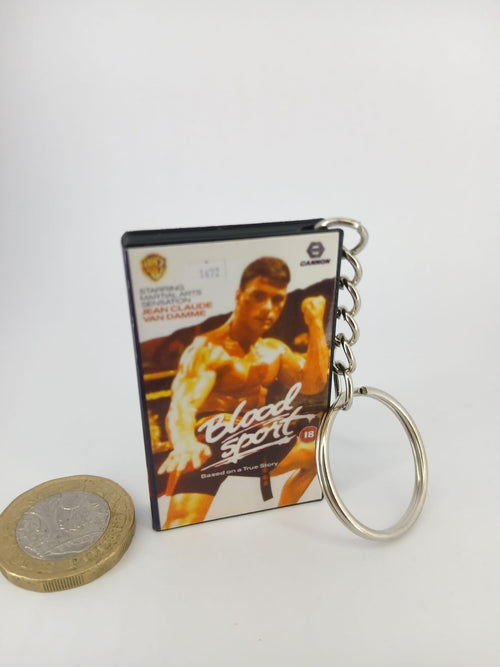 Bloodsport VHS keyring — front cover standing with coin for scale