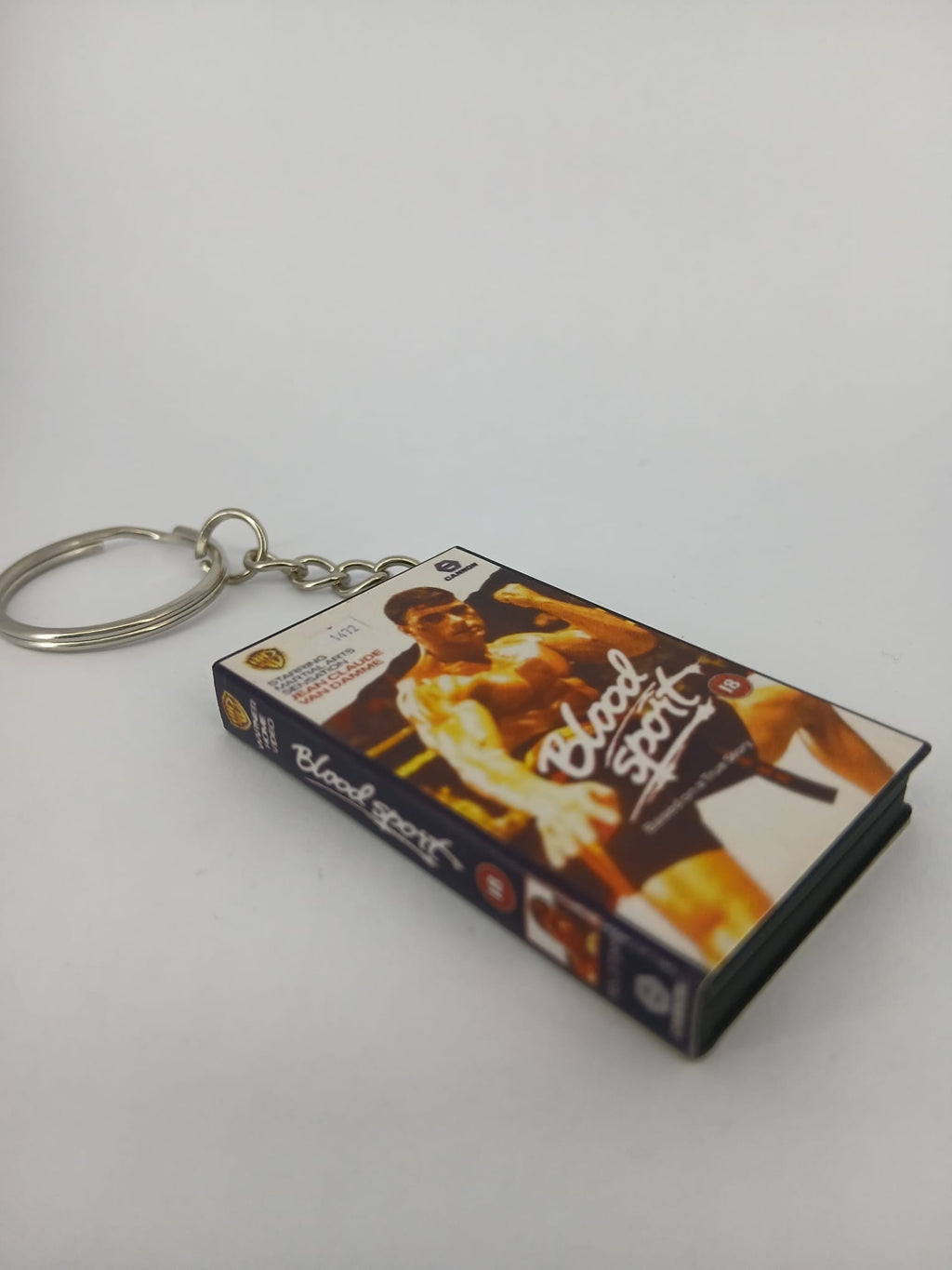Bloodsport VHS keyring — back cover standing angled