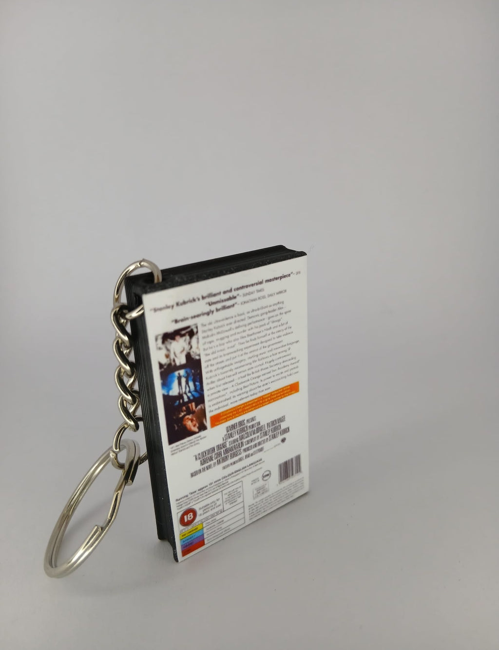 A Clockwork Orange VHS keyring — spine view standing