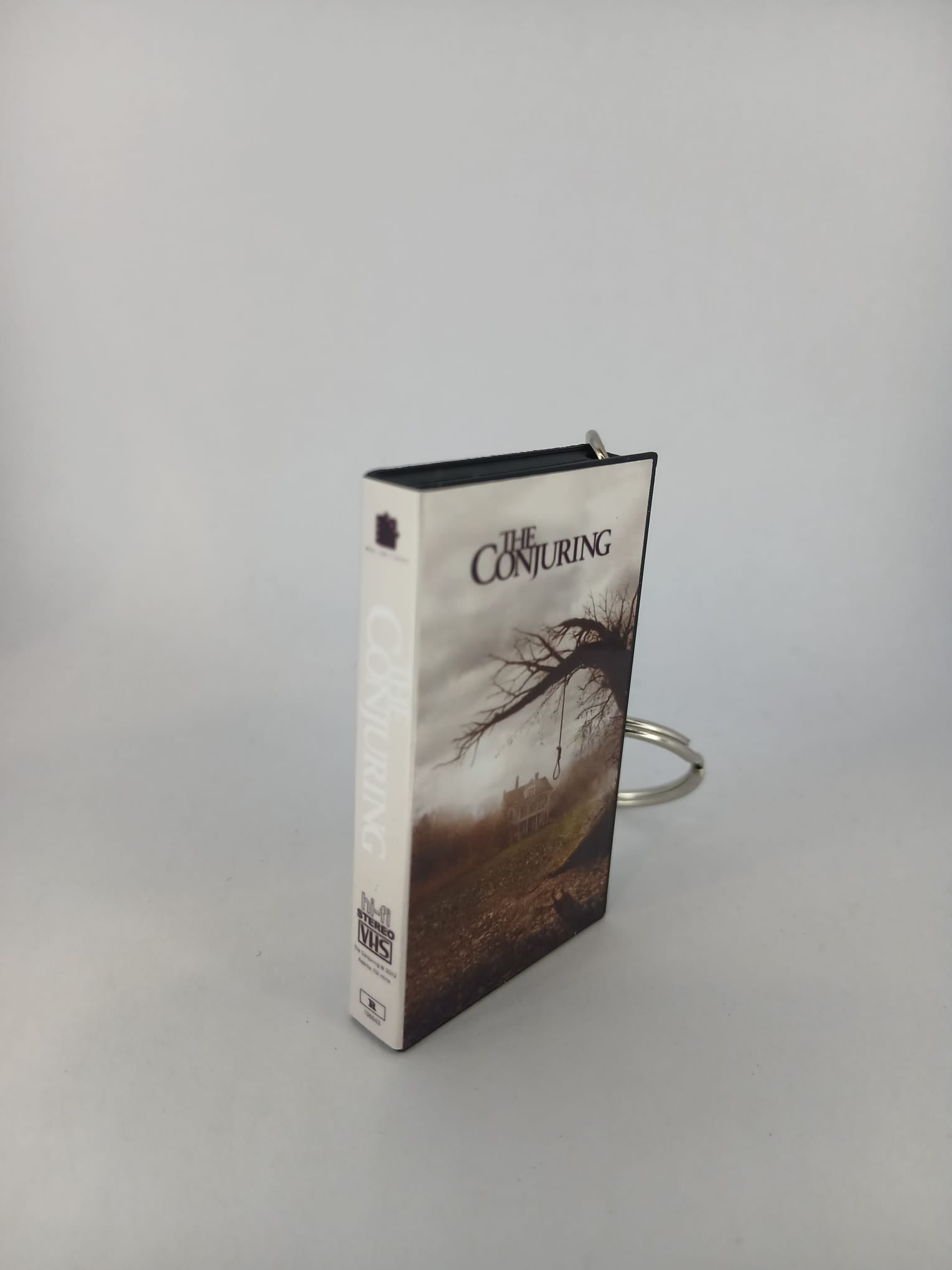 The Conjuring VHS keyring — spine and front angled view