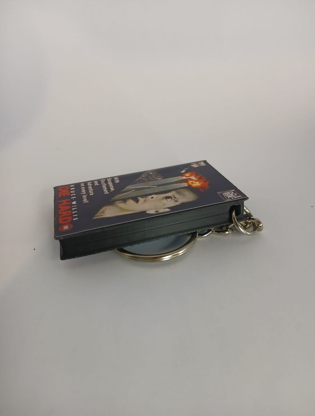 Die Hard VHS keyring — back and spine angled view standing