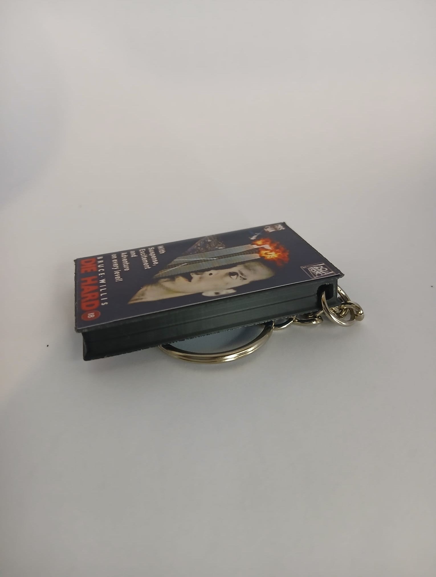 Die Hard VHS keyring — back and spine angled view standing