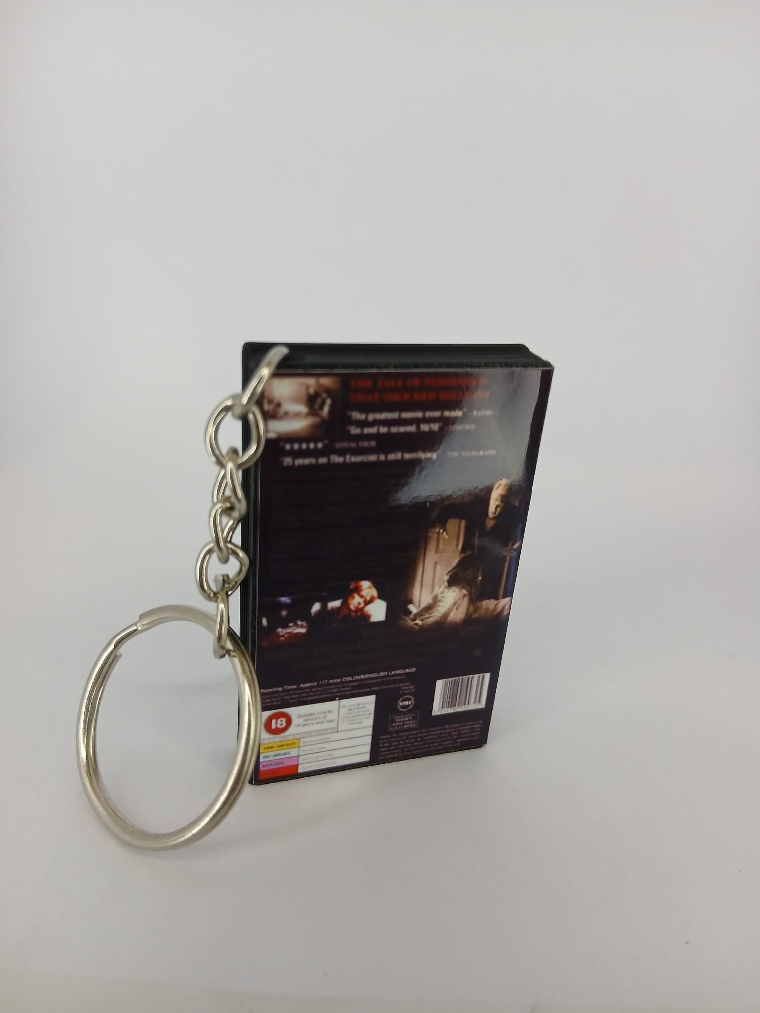 The Exorcist VHS keyring — back and spine angled view standing