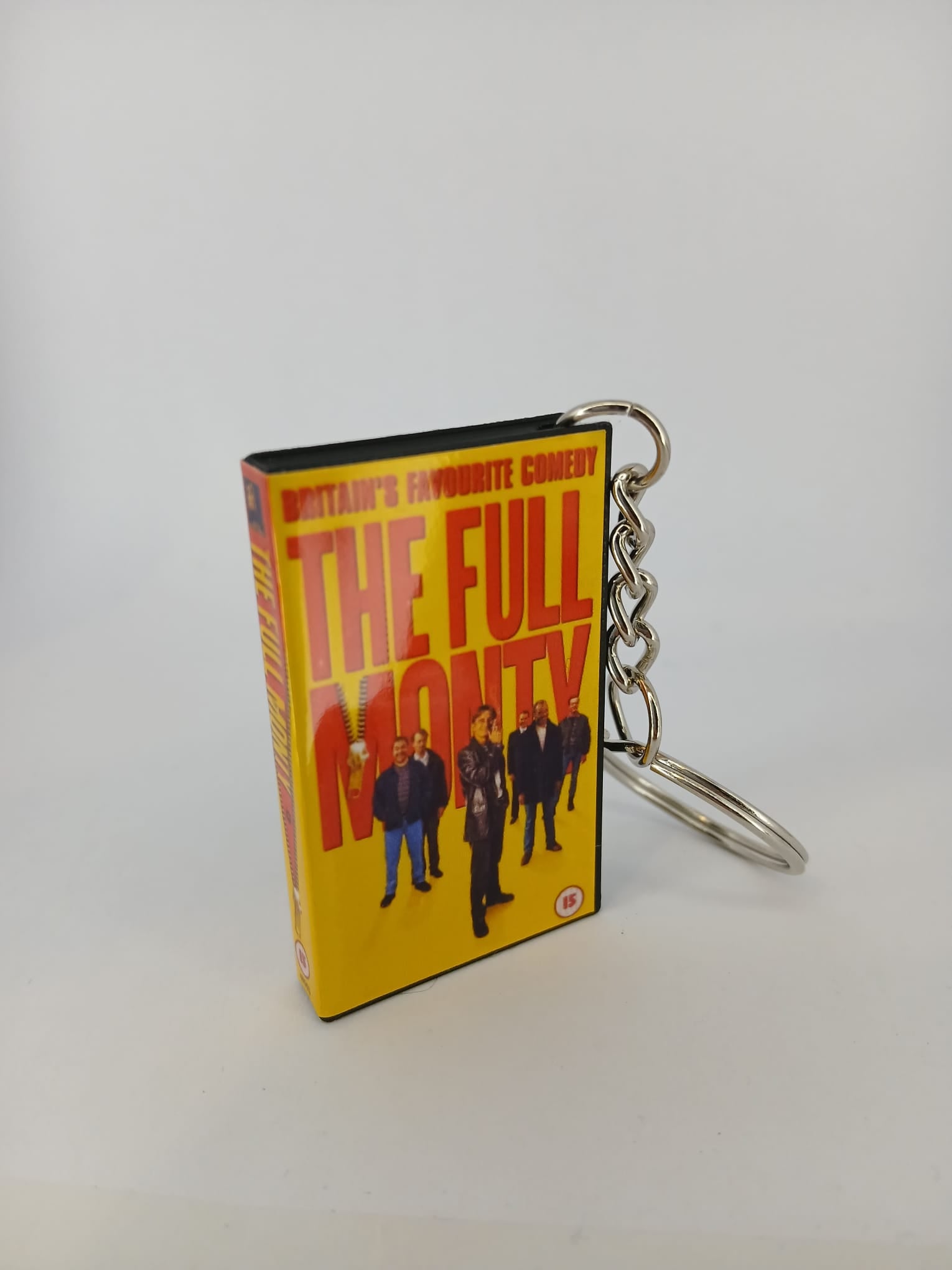 The Full Monty VHS keyring — front cover standing with coin for scale