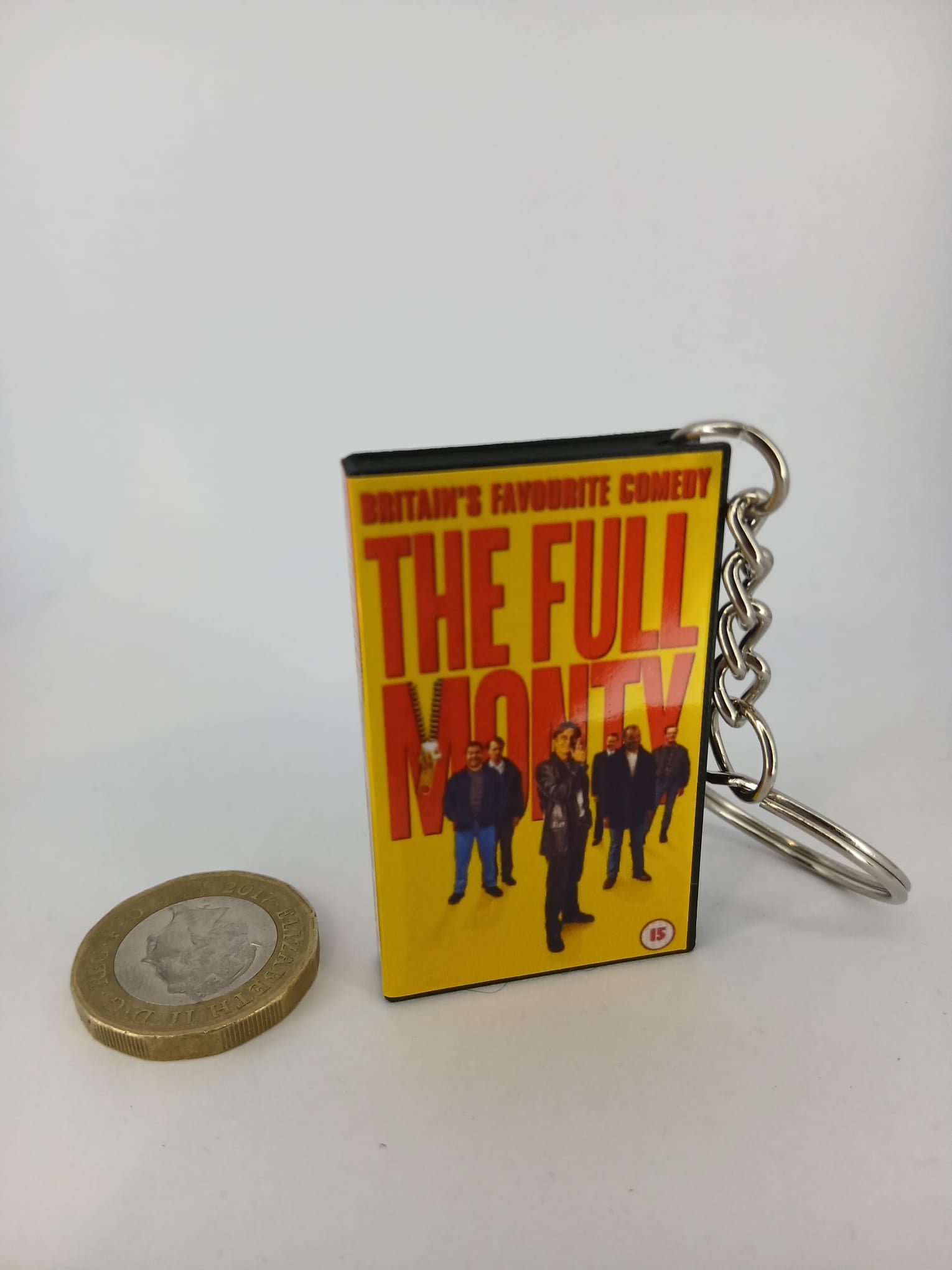 The Full Monty VHS keyring — front cover standing with coin for scale 2