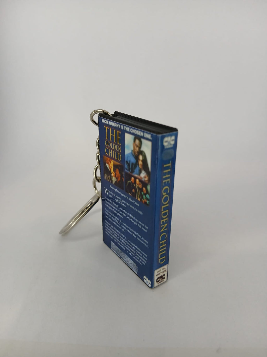 The Golden Child VHS keyring — spine and front angled view standing