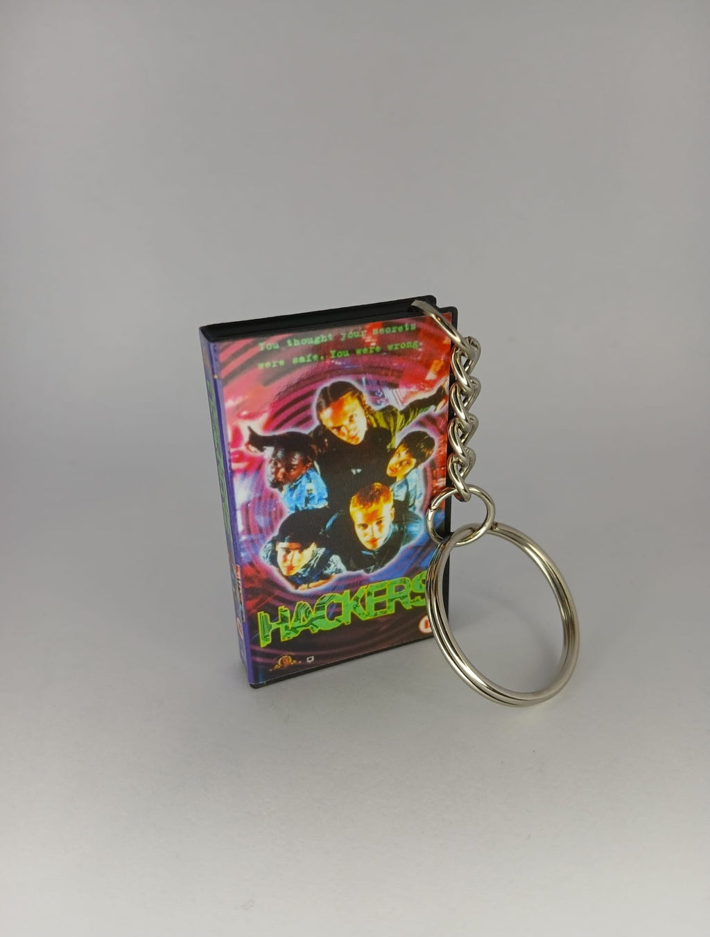 Hackers VHS keyring — back cover angled view standing