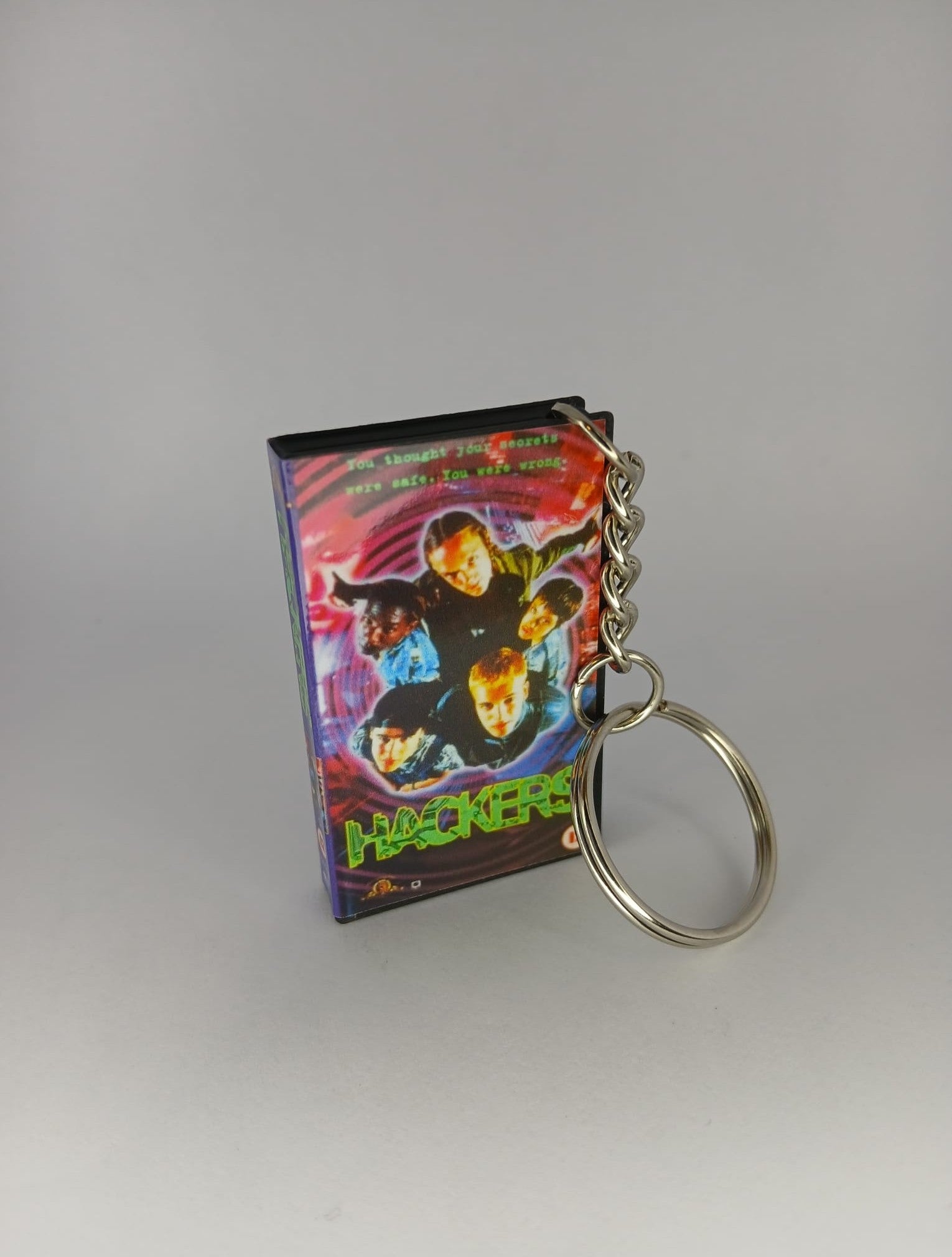 Hackers VHS keyring — back cover angled view standing