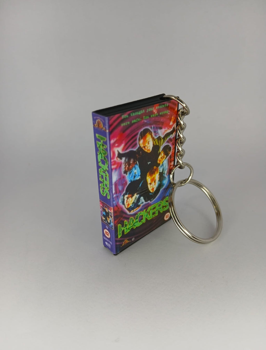 Hackers VHS keyring — back and spine angled view standing