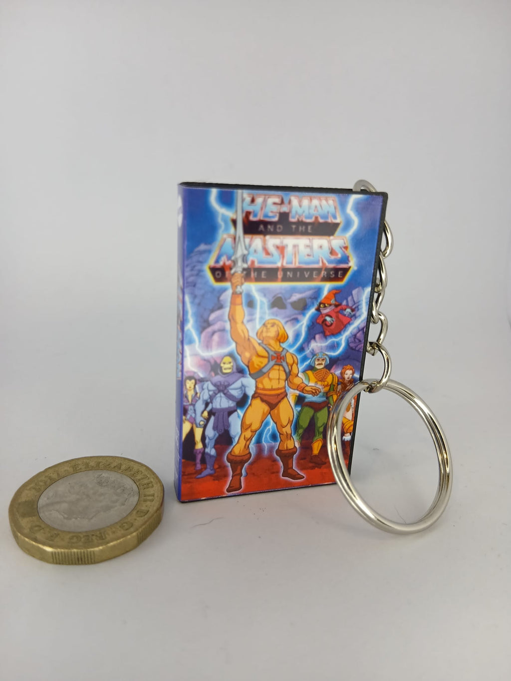 He-Man VHS keyring size comparison with coin