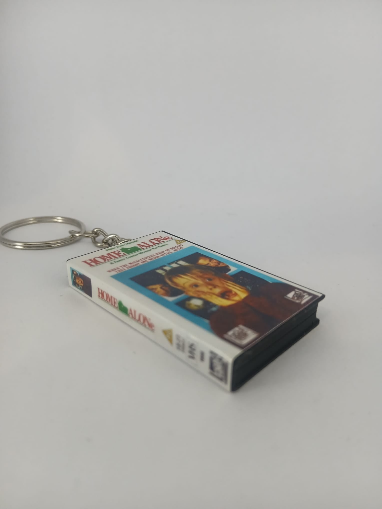 Home Alone VHS keyring — front cover standing angled