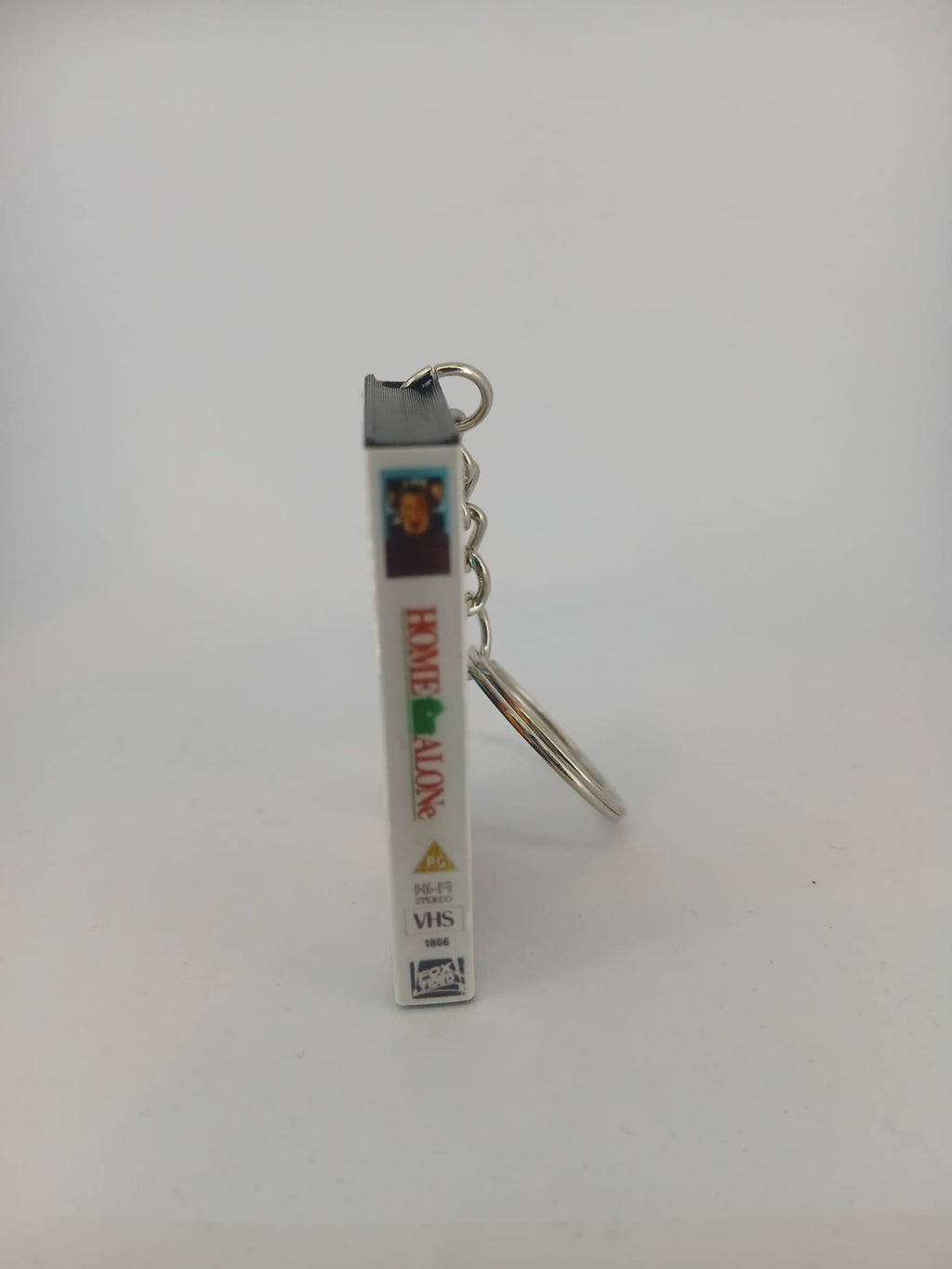 Home Alone VHS keyring — back cover standing with review quotes visible