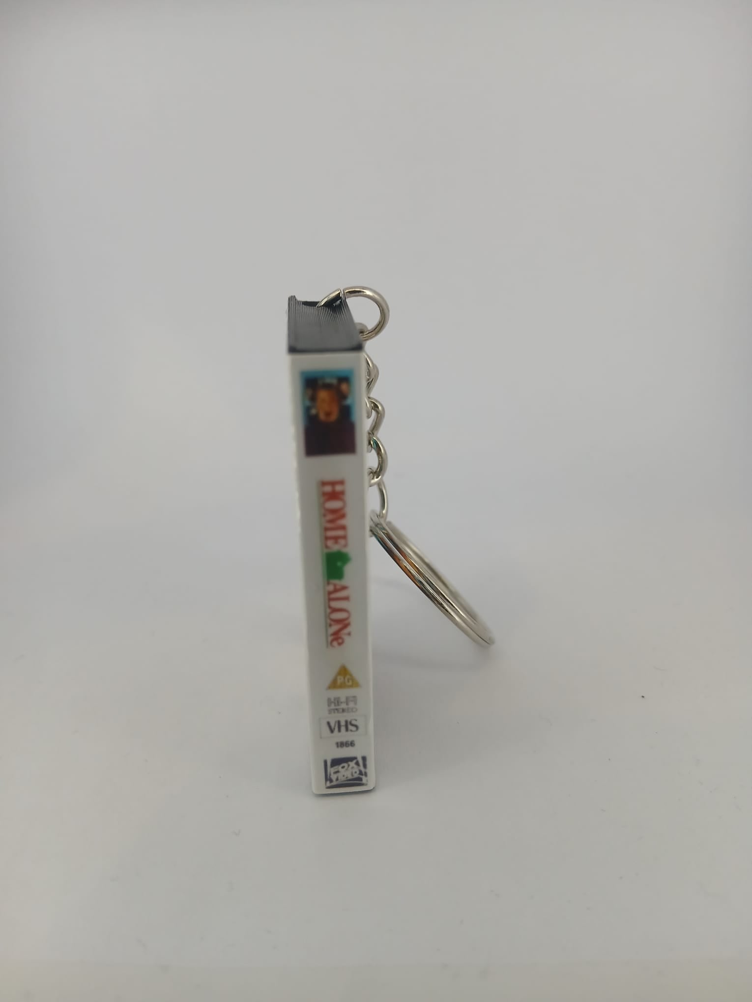 Home Alone VHS keyring — back cover standing with review quotes visible