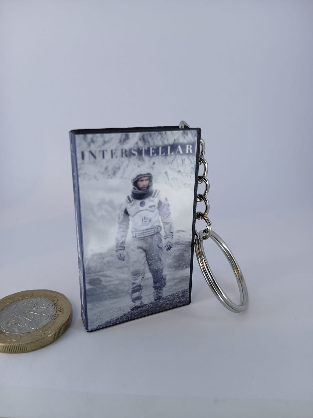 Interstellar VHS keyring — front cover with £1 coin for scale