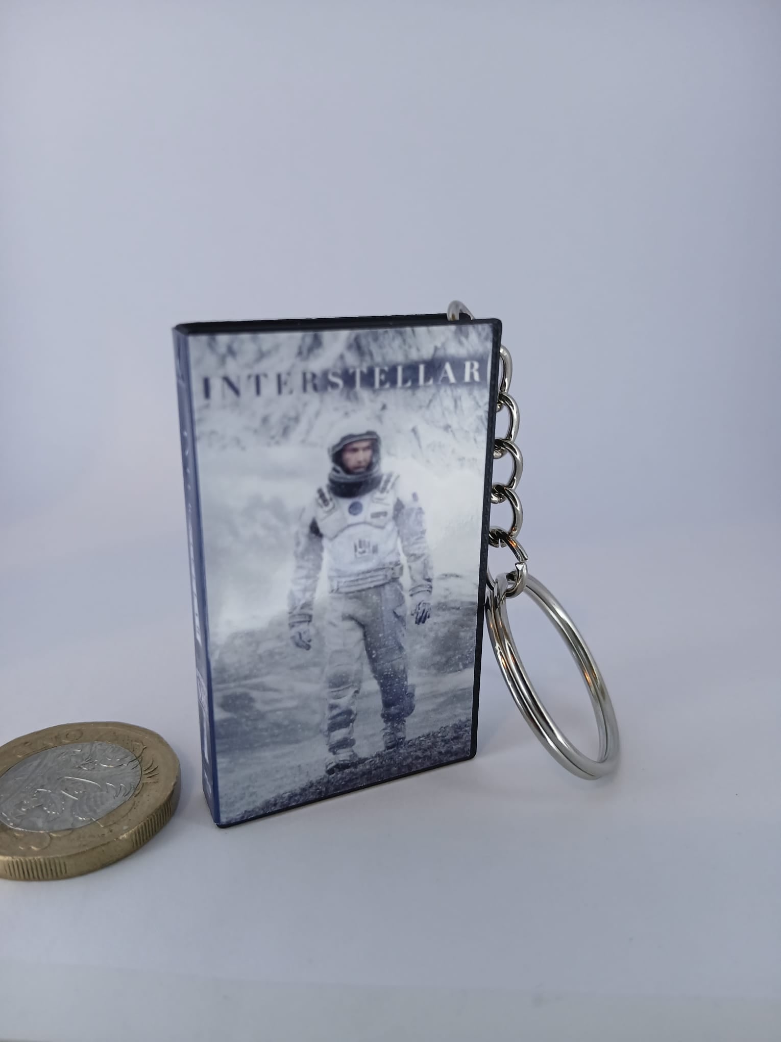 Interstellar VHS keyring — front cover with £1 coin for scale