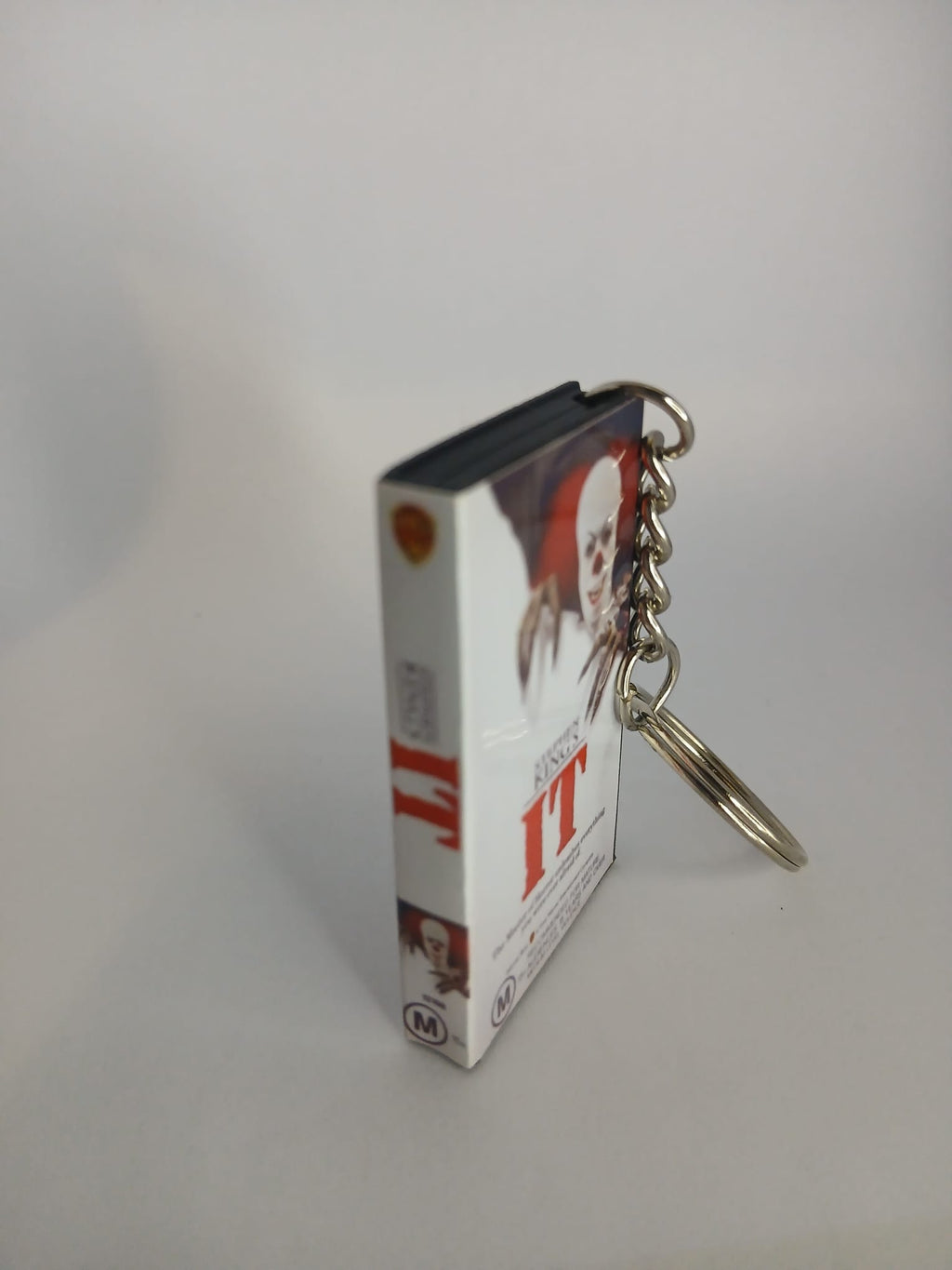 Stephen King's IT VHS keyring — back and spine angled view standing