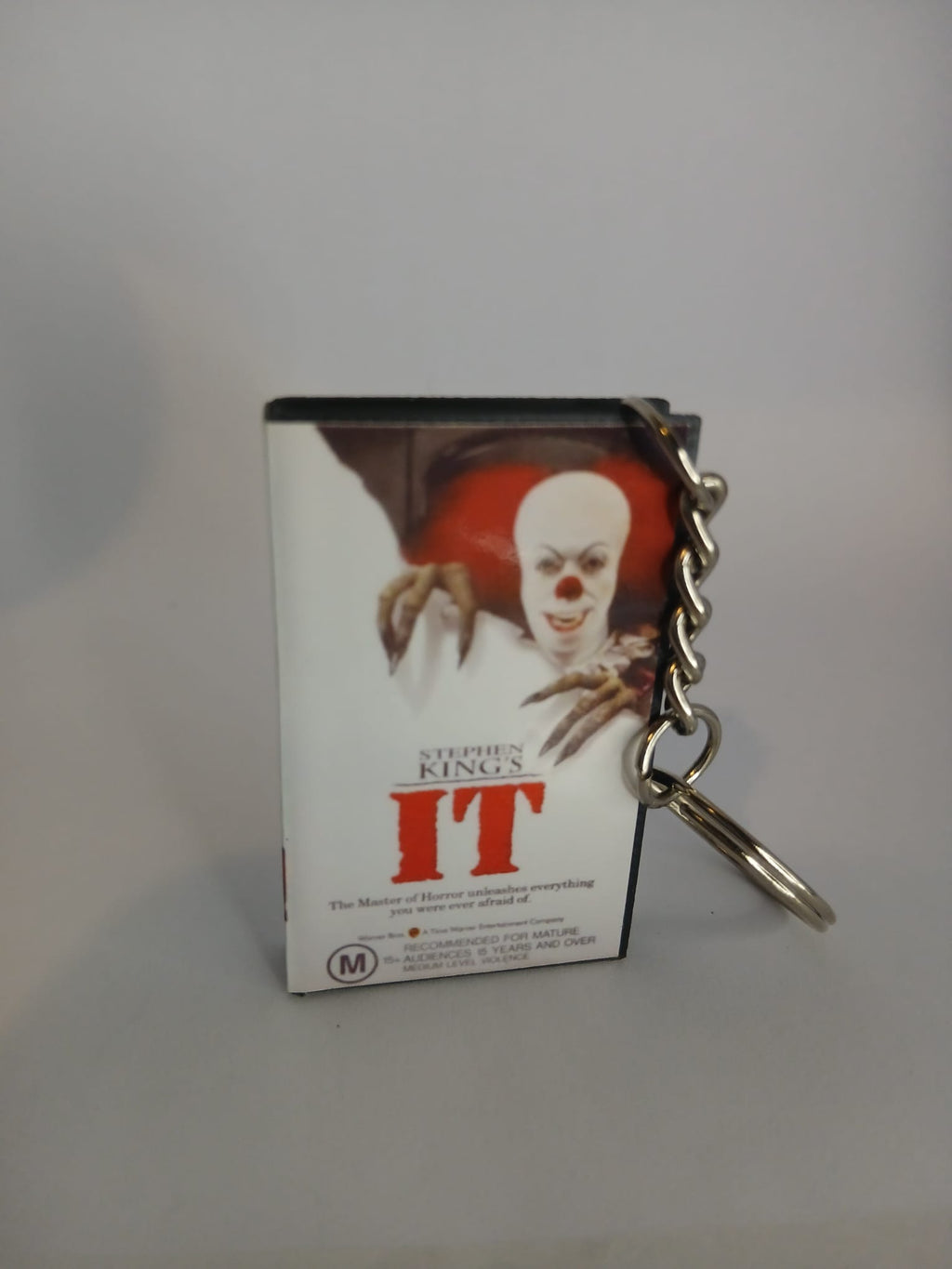 Stephen King's IT VHS keyring — front cover standing with coin for scale