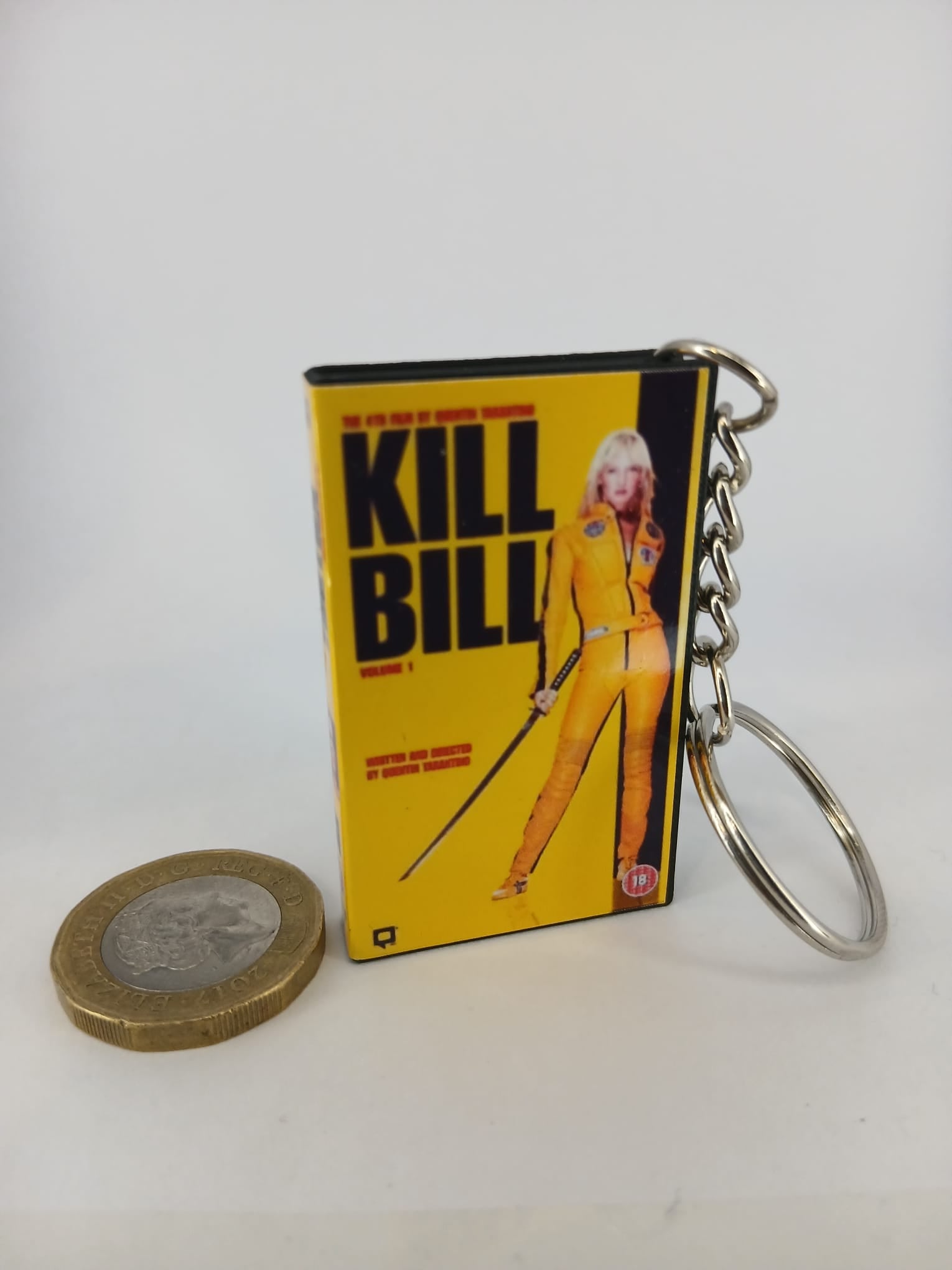 Kill Bill Volume 1 VHS keyring — front cover standing with coin for scale