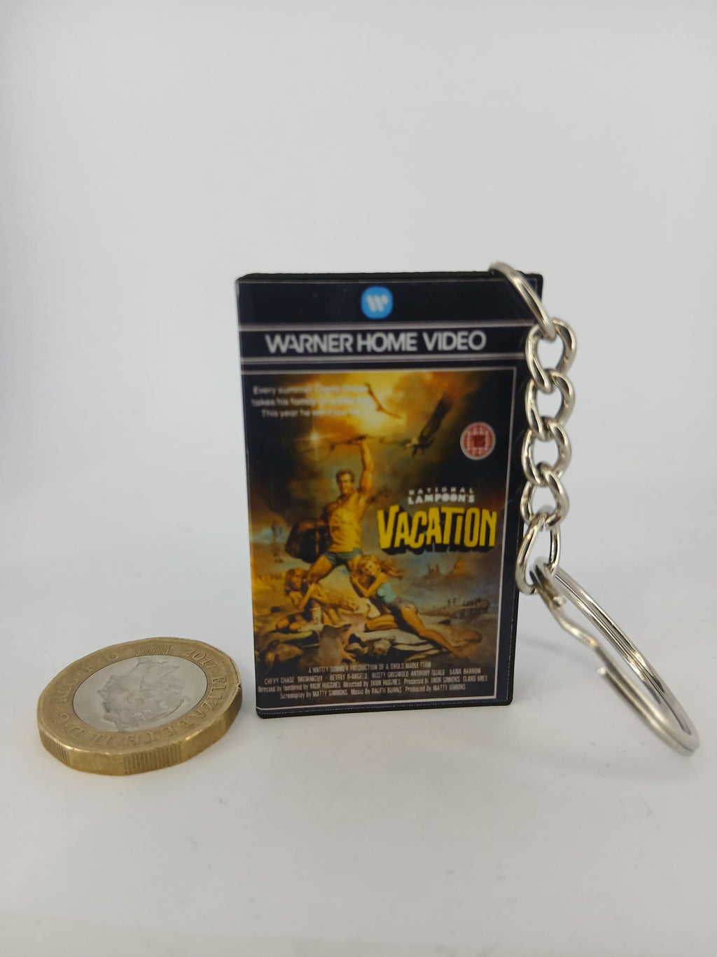 National Lampoon's Vacation VHS keyring — front cover standing with coin for scale