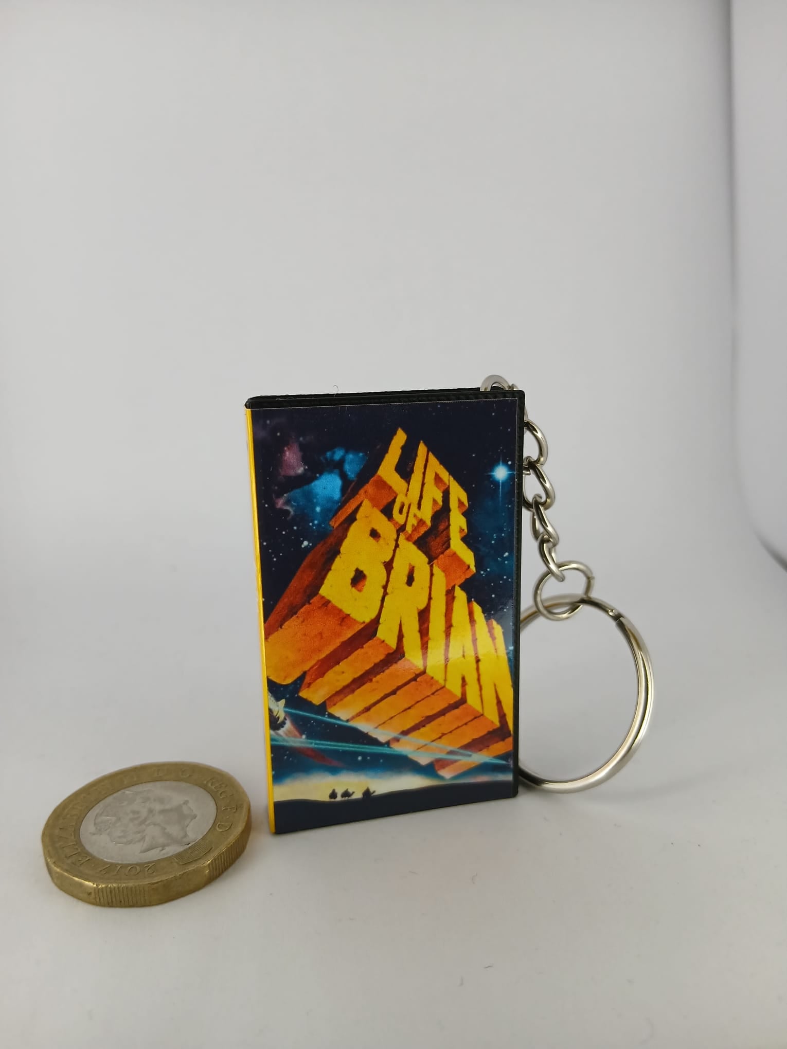 Monty Python's Life of Brian VHS keyring — front cover with £1 coin for scale