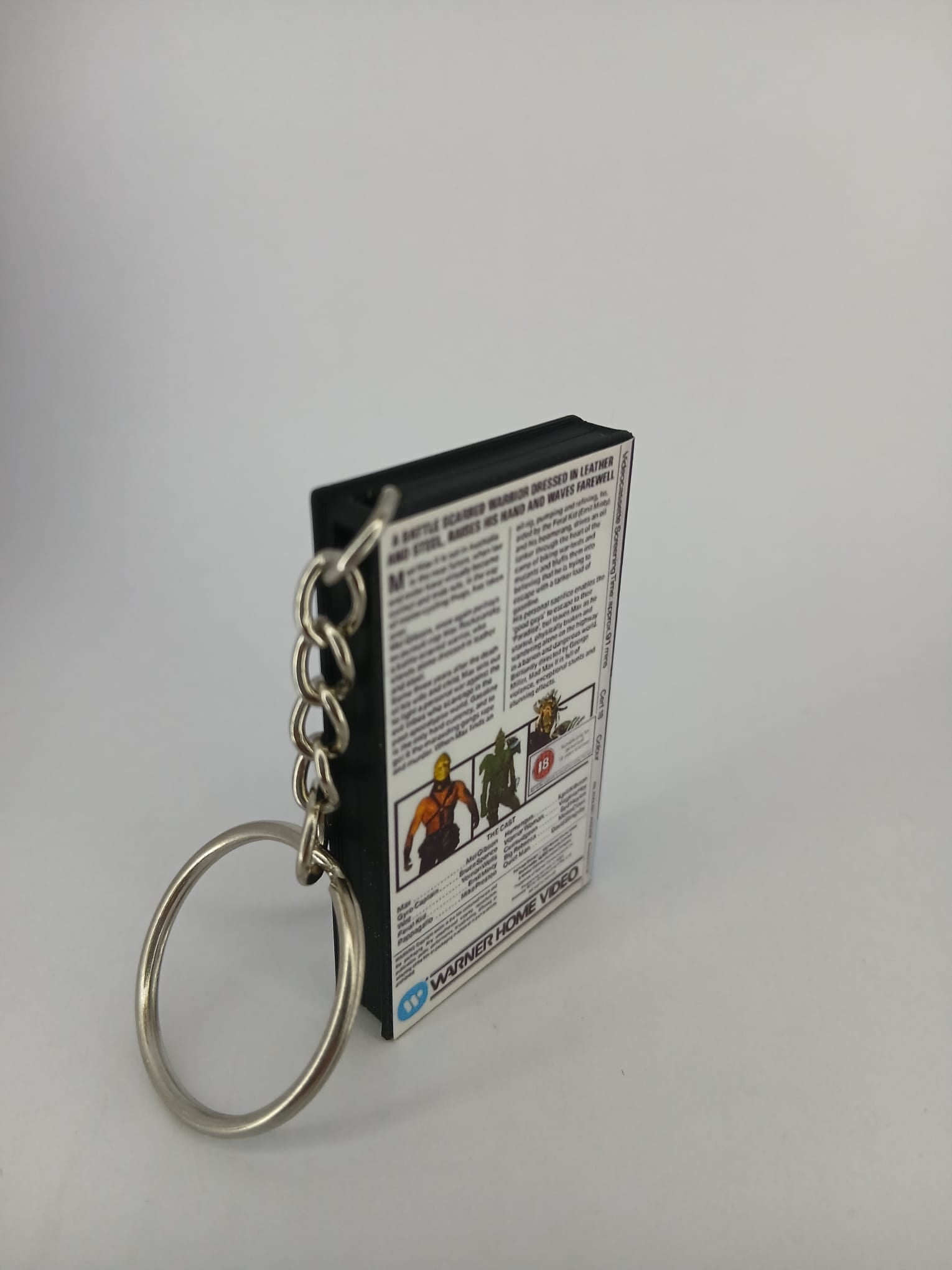 Mad Max 2 VHS keyring — back and spine angled view standing