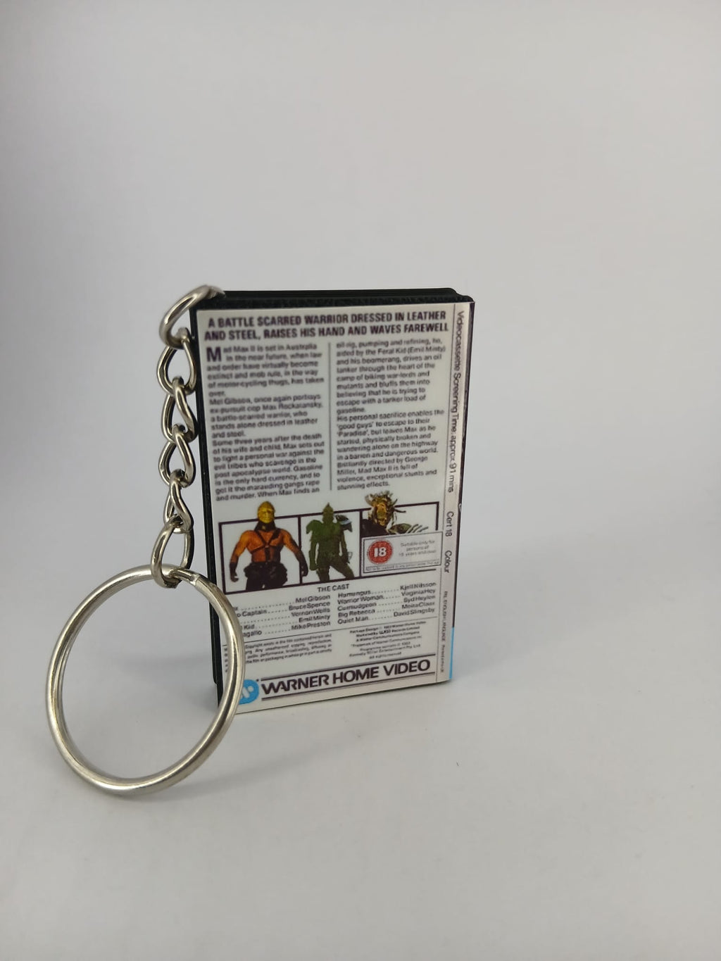 Mad Max 2 VHS keyring — front and spine angled view standing