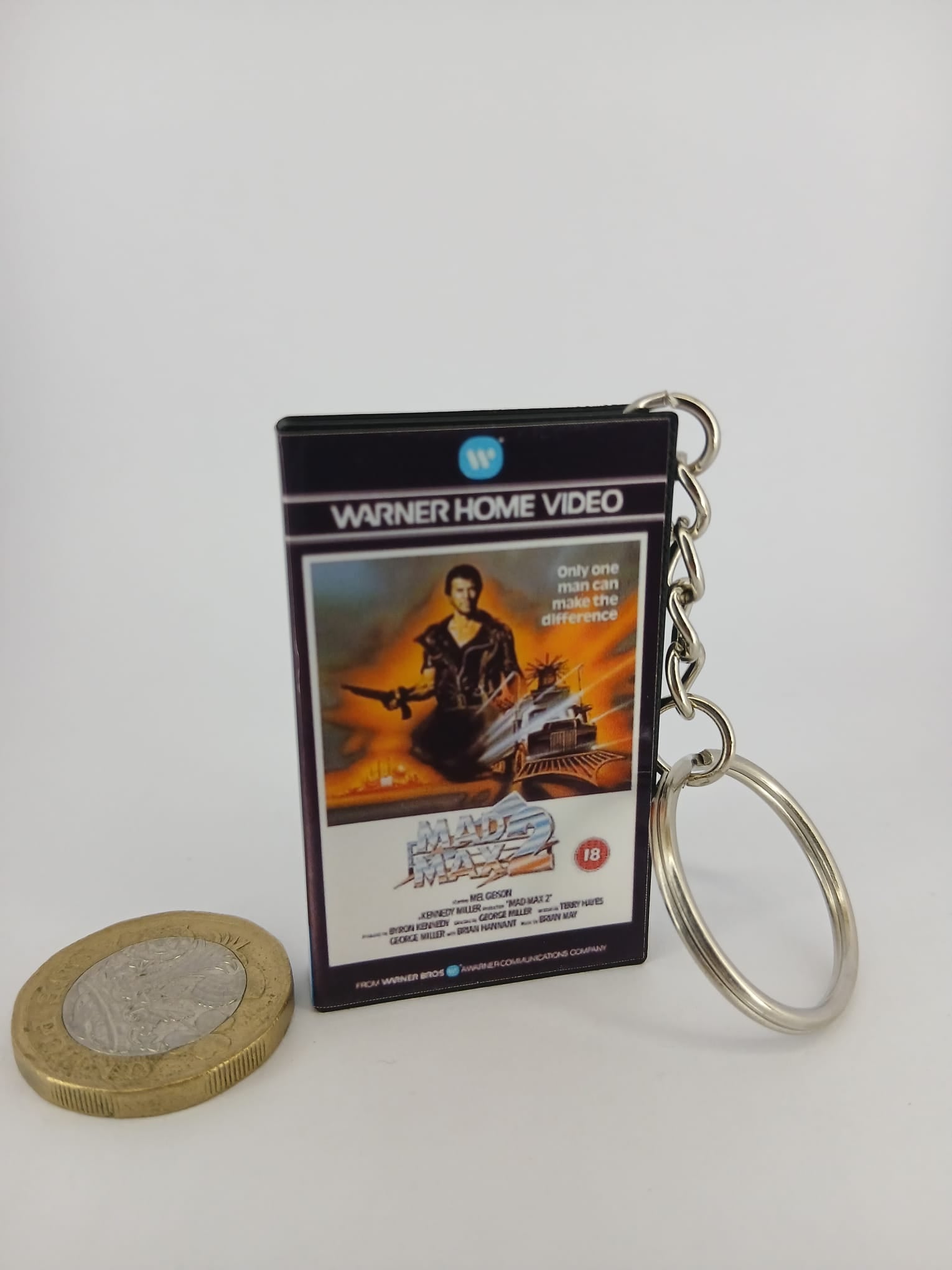 Mad Max 2 VHS keyring — front cover standing with coin for scale
