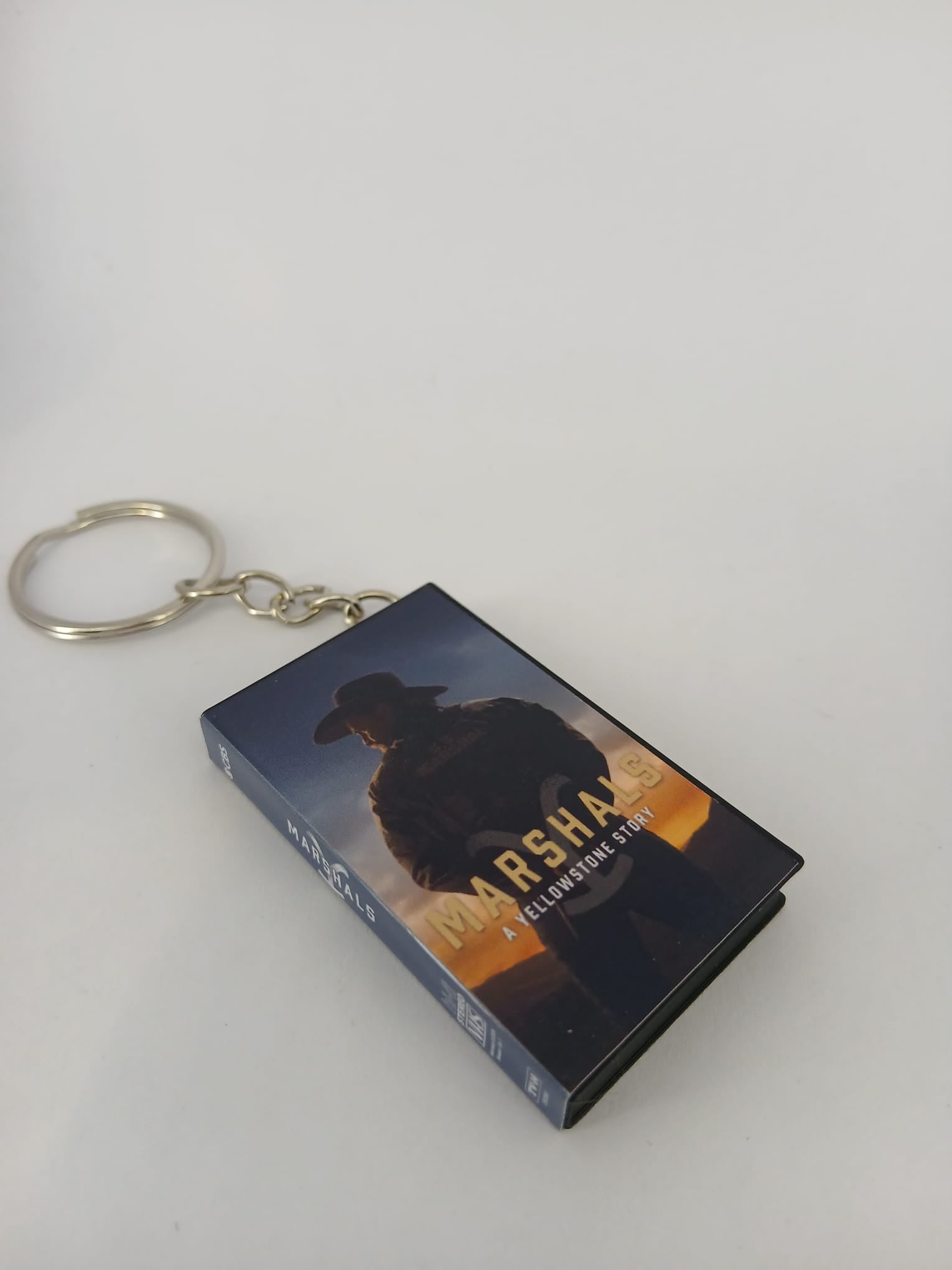 Marshals: A Yellowstone Story VHS keyring — front cover flat lay angled 2