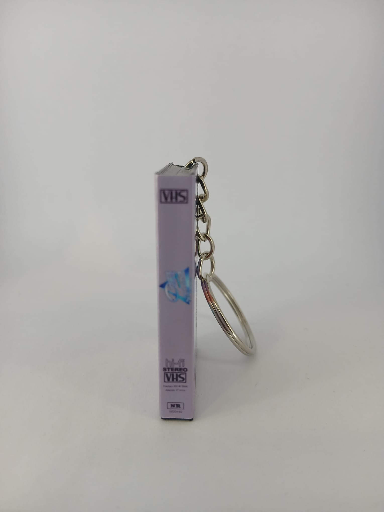 Captain EO VHS keyring — front cover standing with coin for scale