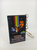 Moonwalker VHS keyring — front cover standing with coin for scale