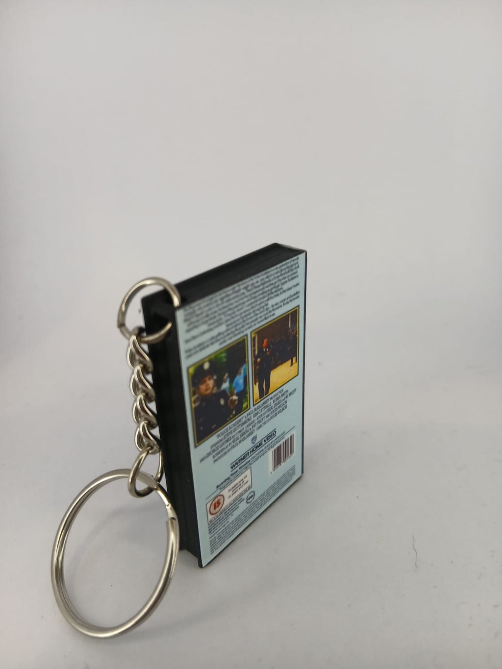 Police Academy VHS keyring — back and spine angled view standing