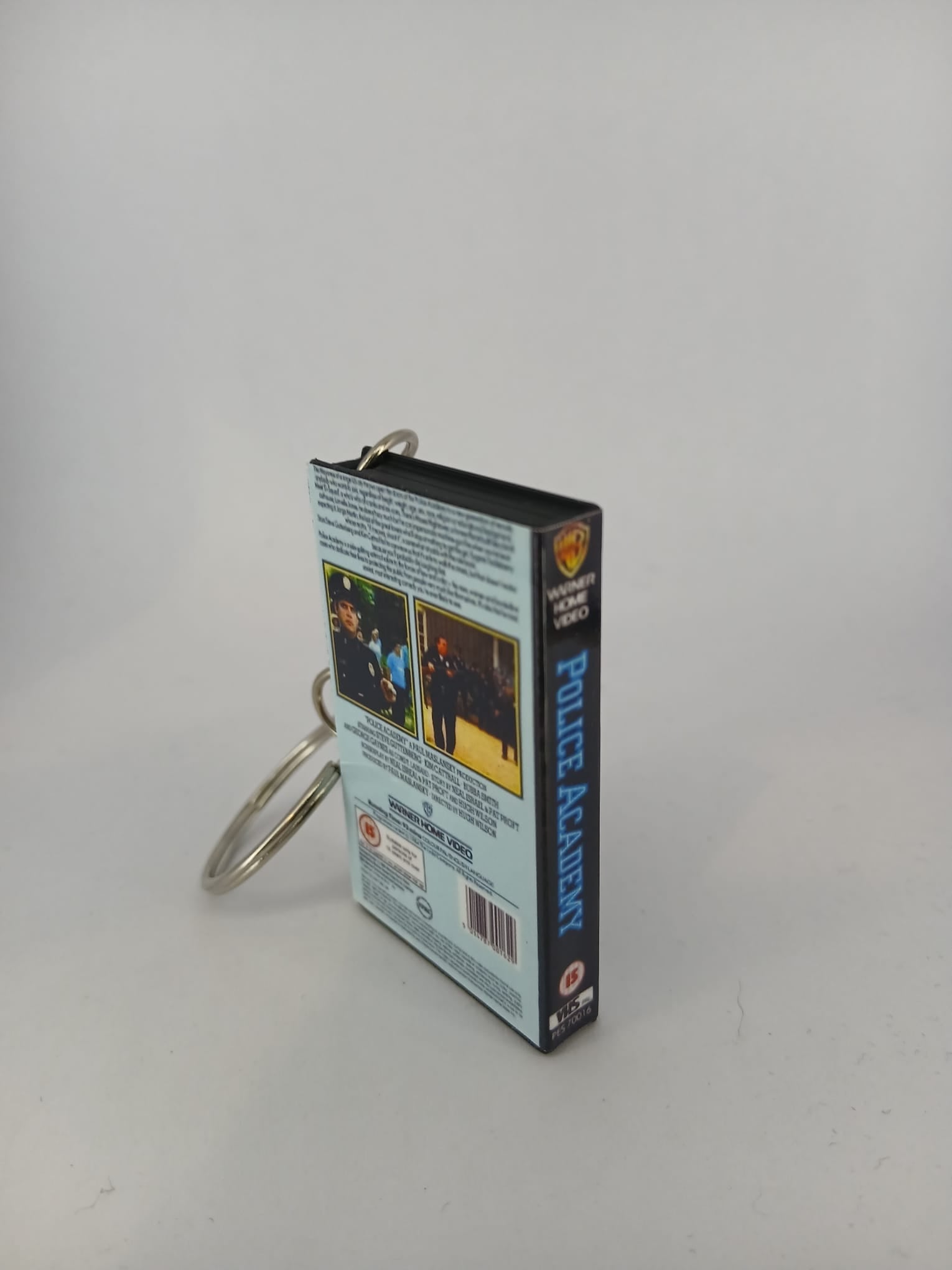 Police Academy VHS keyring — spine and front angled view standing