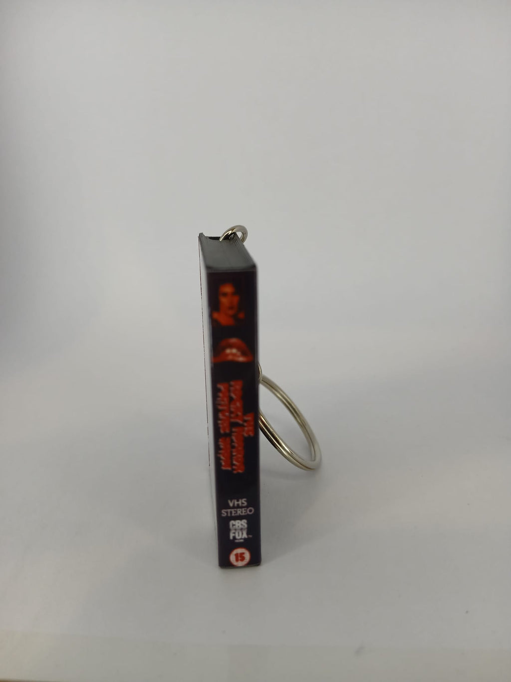The Rocky Horror Picture Show VHS keyring — front and spine angled view standing