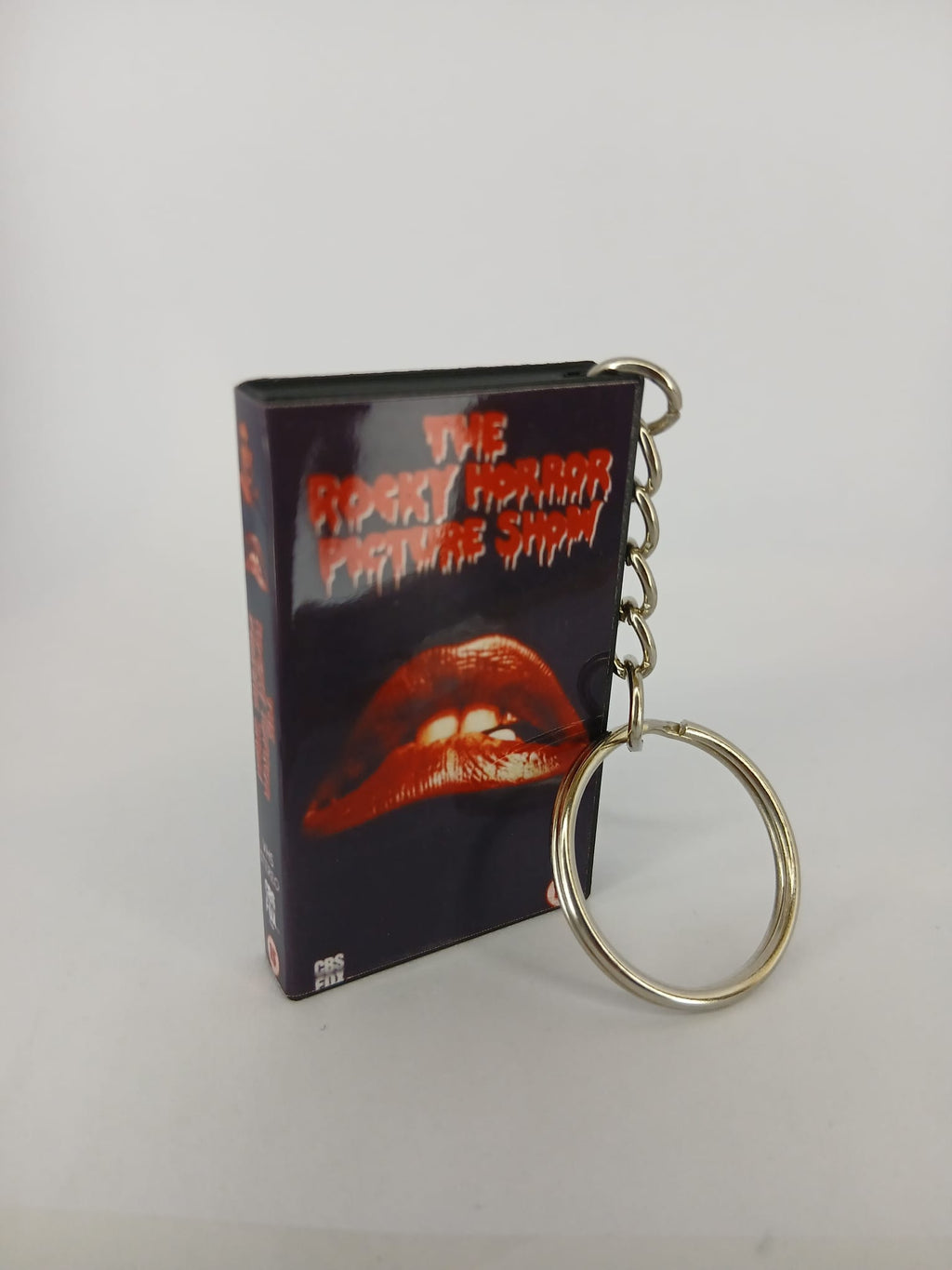 The Rocky Horror Picture Show VHS keyring — back cover angled view standing