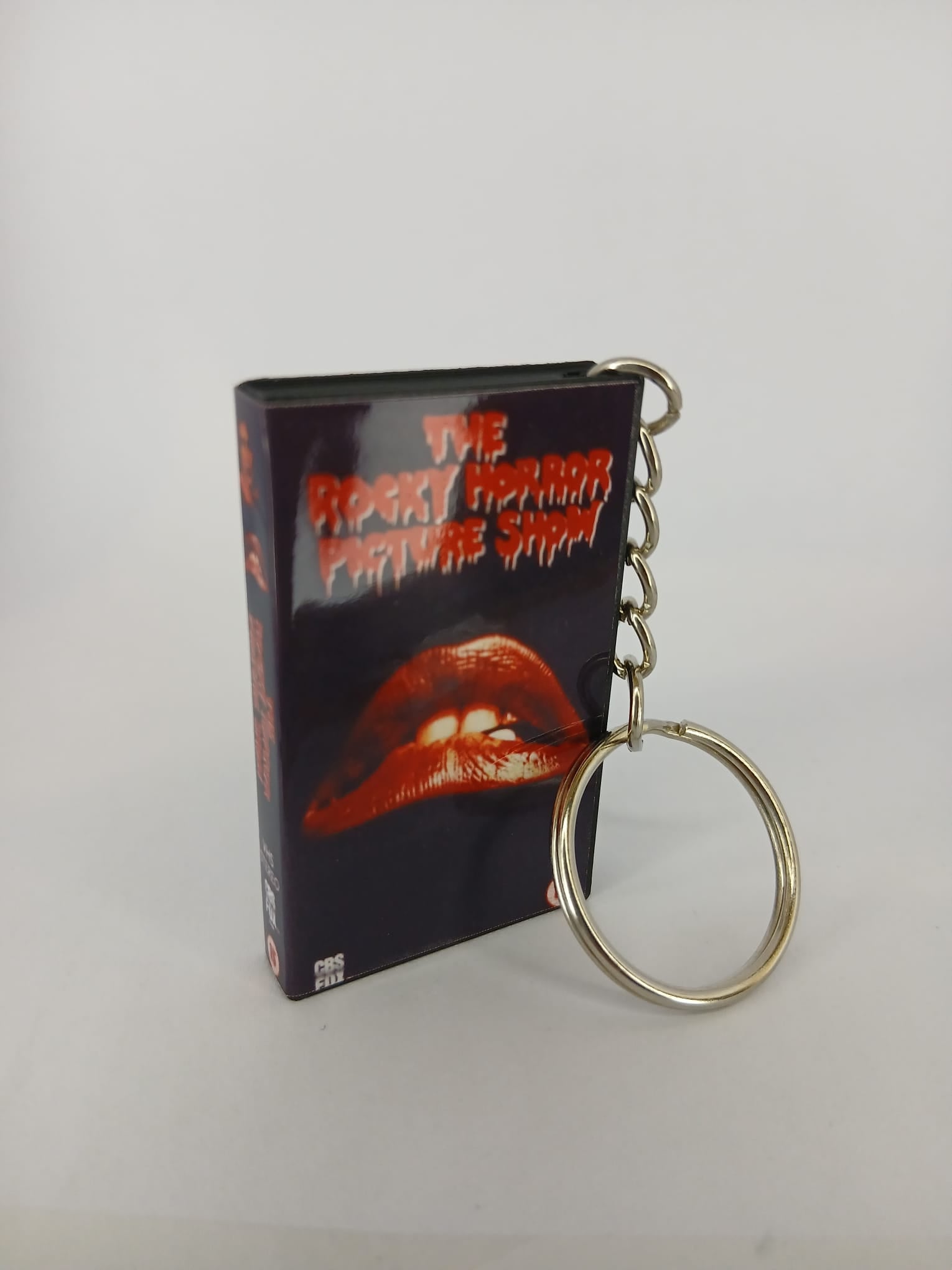The Rocky Horror Picture Show VHS keyring — back cover angled view standing