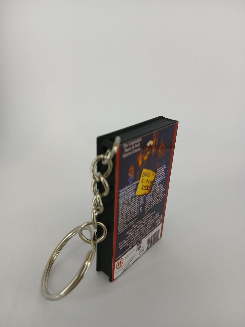 The Rocky Horror Picture Show VHS keyring — back and spine angled view standing