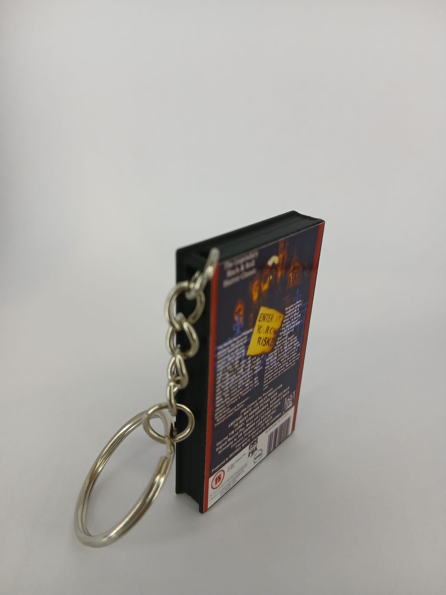 The Rocky Horror Picture Show VHS keyring — back and spine angled view standing