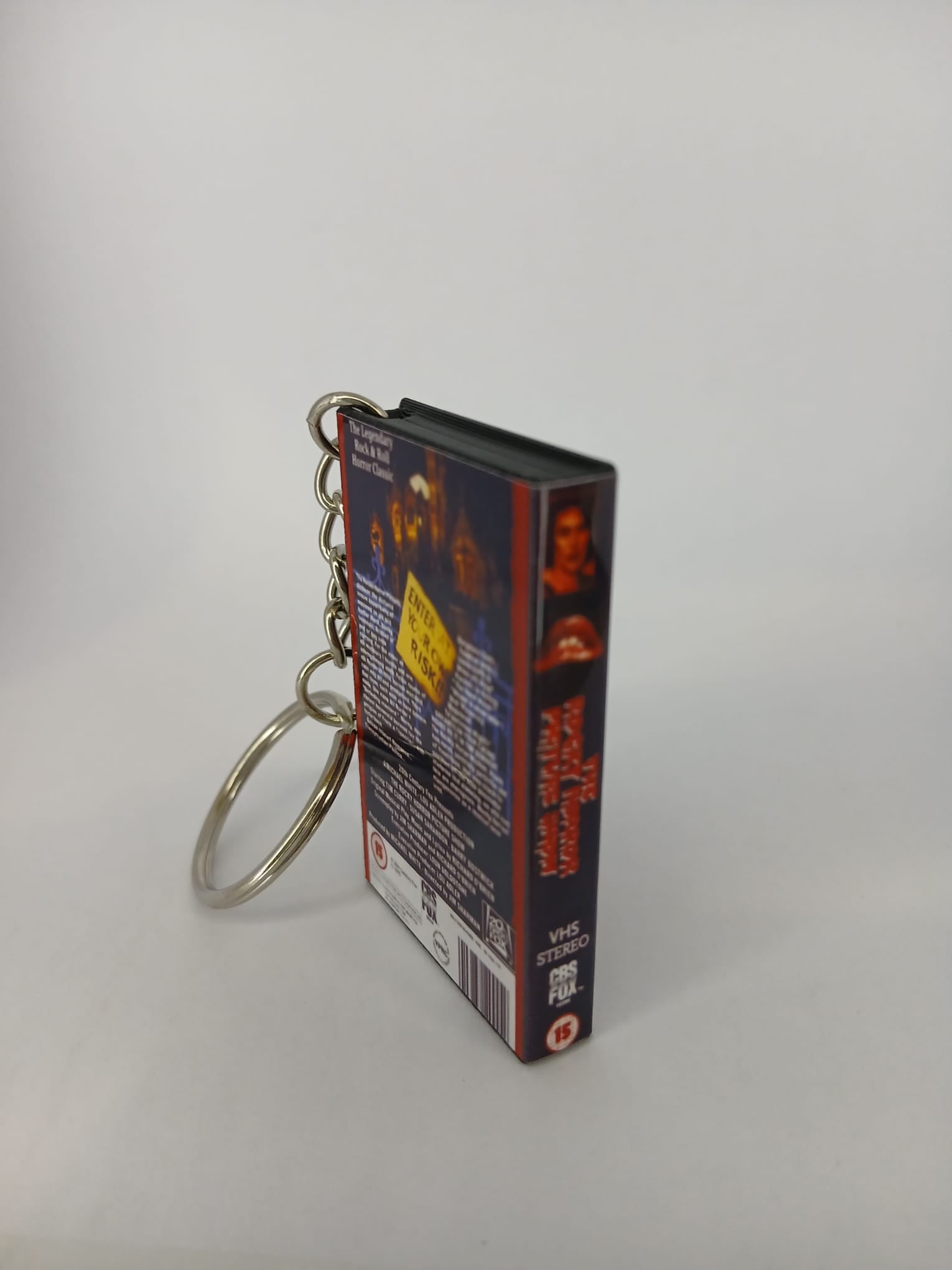 The Rocky Horror Picture Show VHS keyring — spine view standing