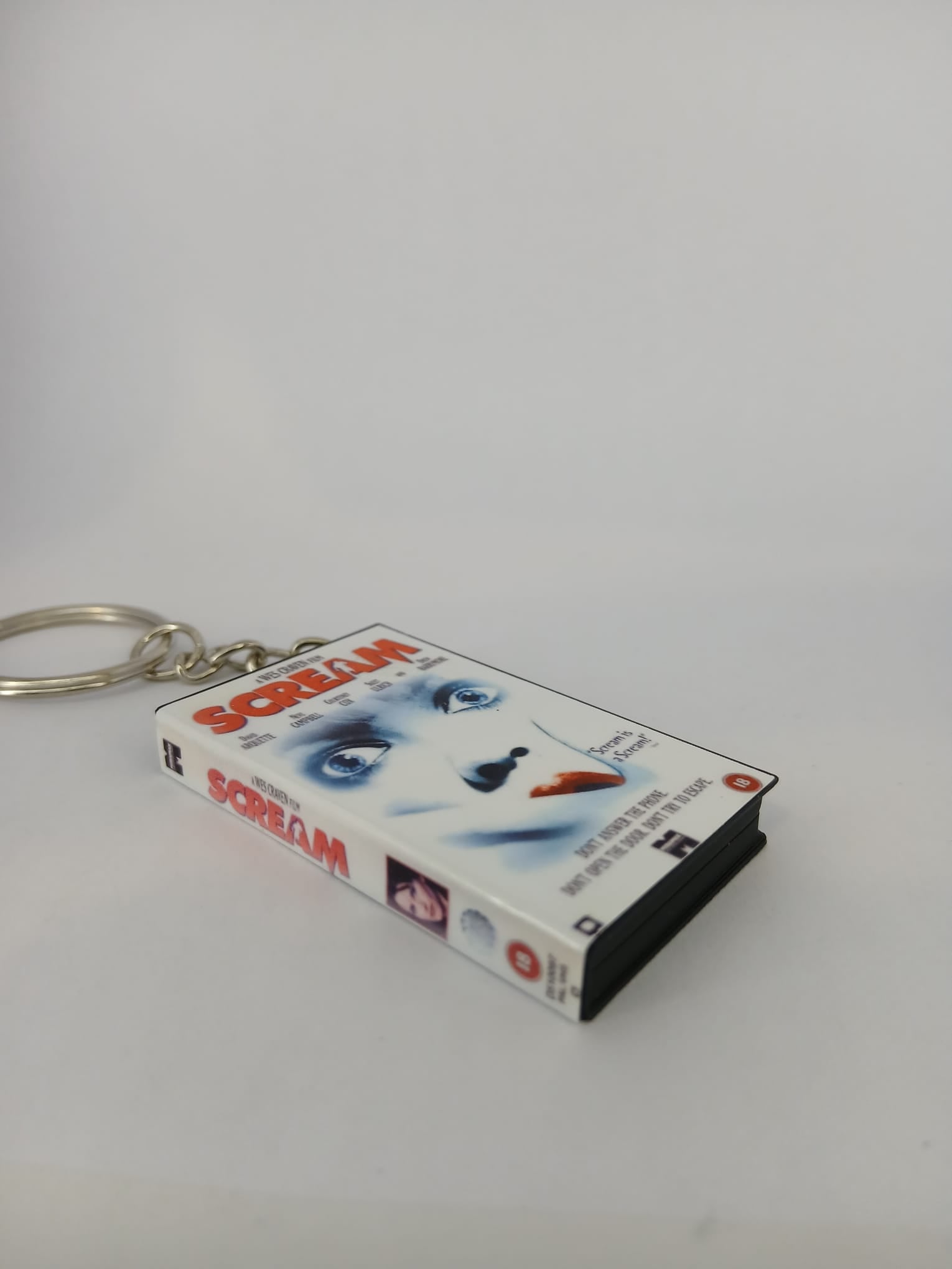 Scream VHS keyring — back and spine angled view standing