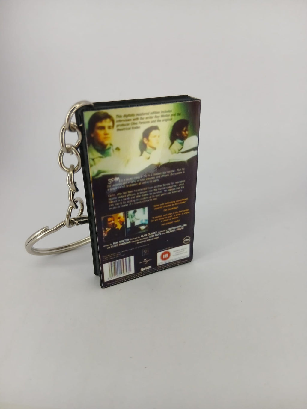 Scum VHS keyring — back and spine angled view standing