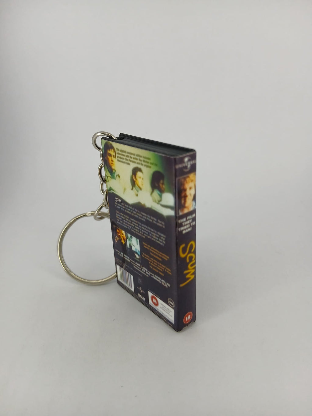 Scum VHS keyring — front cover flat lay angled