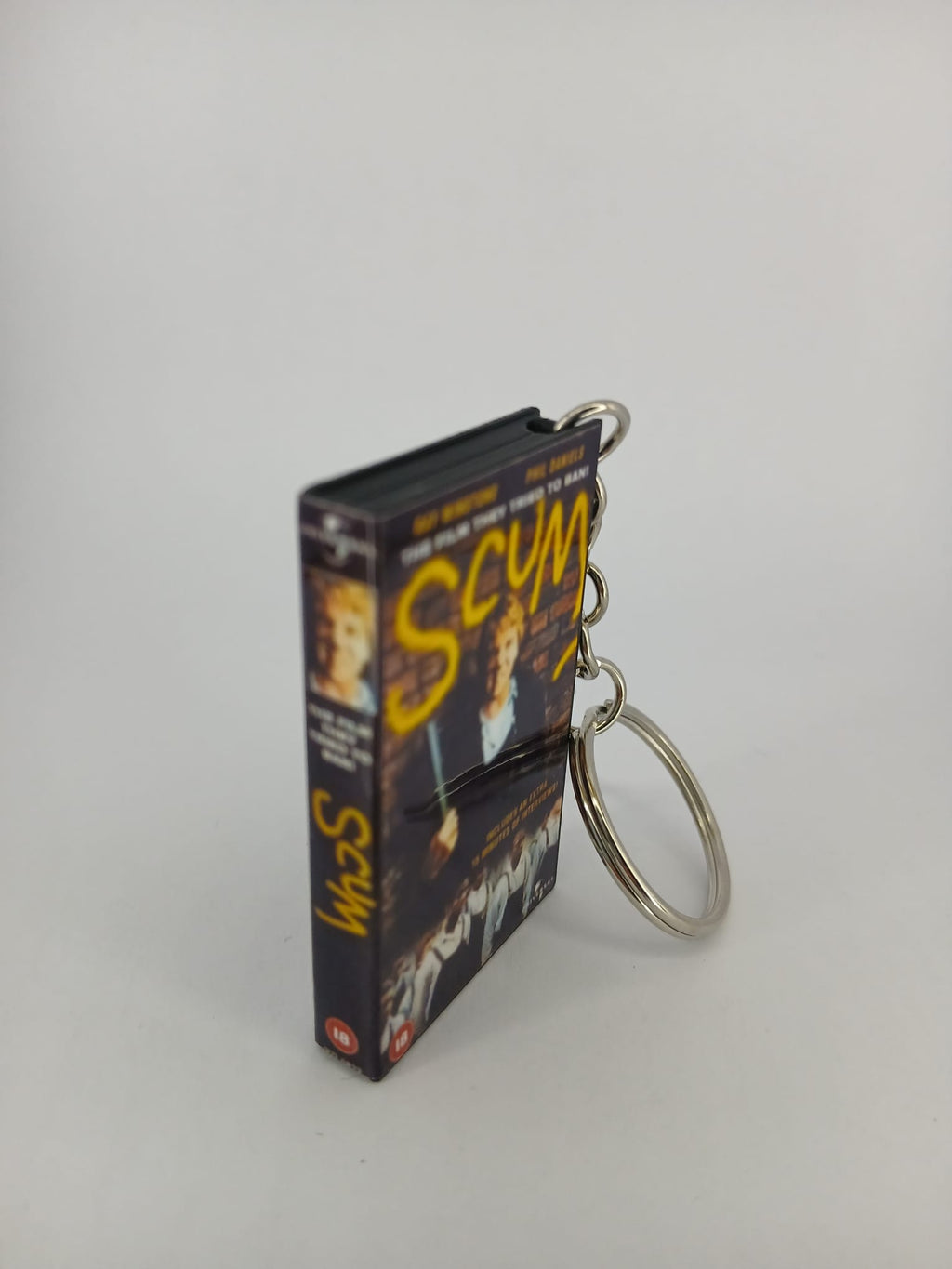 Scum VHS keyring — spine view standing