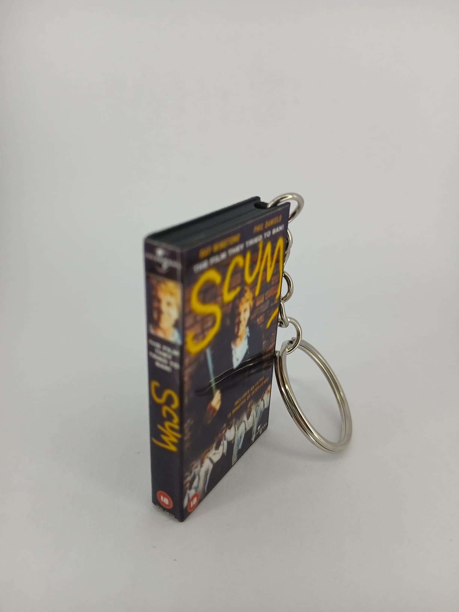 Scum VHS keyring — spine view standing