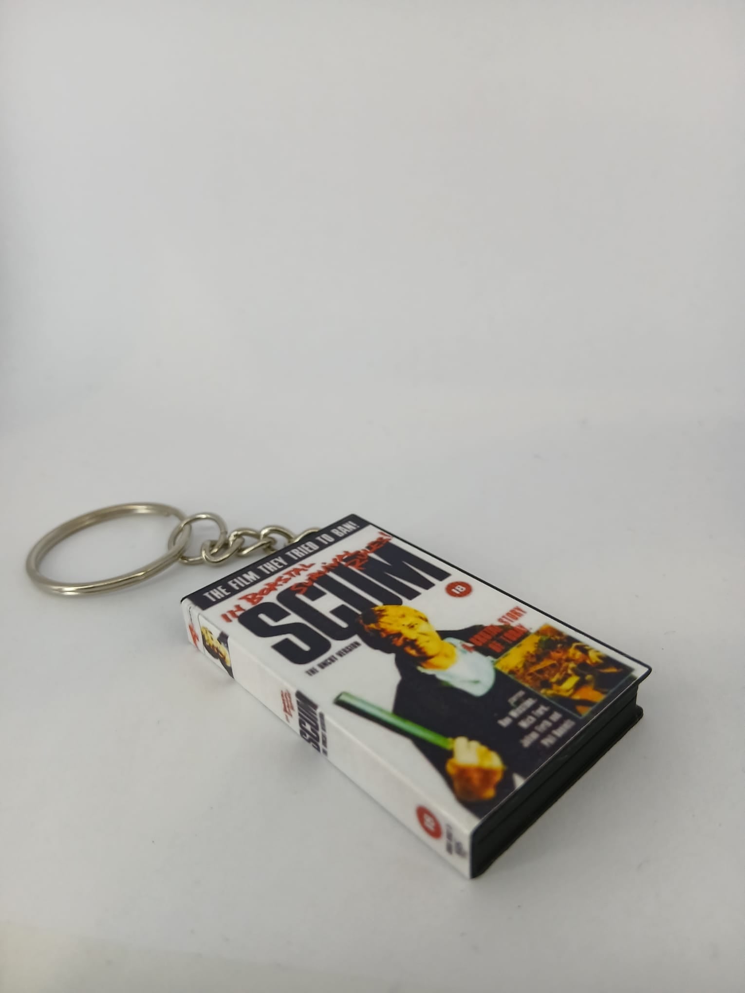 Scum VHS keyring — flat lay front and spine angled