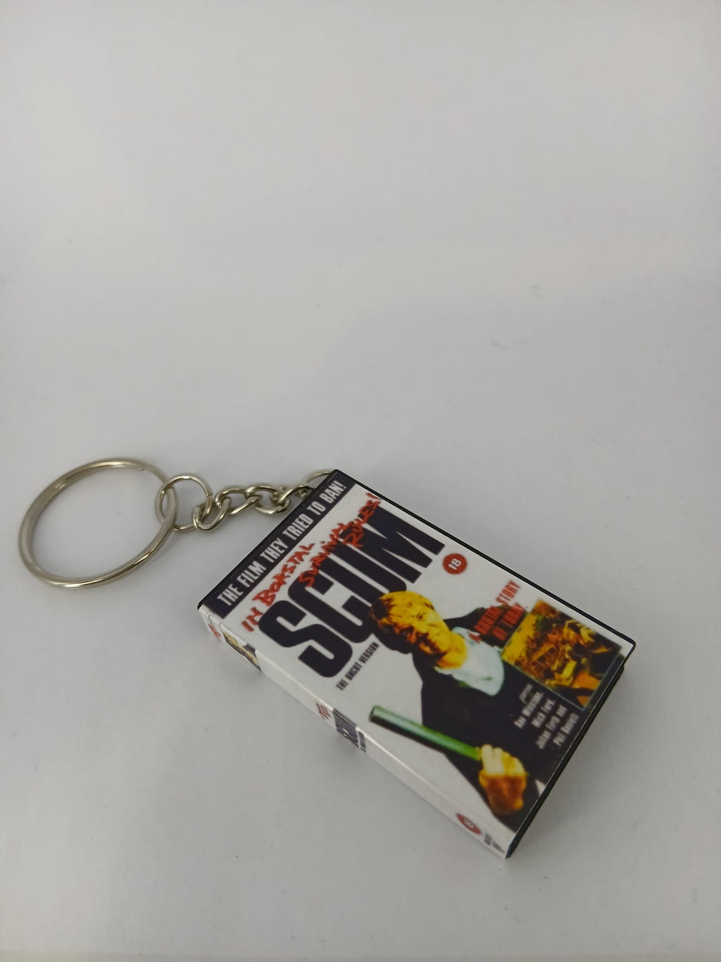 Scum VHS keyring — front cover standing angled 2